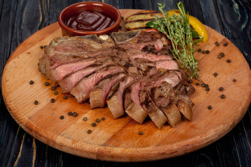 juicy, fried, tender steak with vegetables and sauces on a special stand