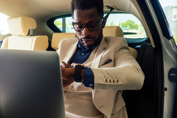 business afro male useing phone route novator map app sitting in car