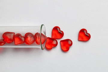 Hearts and test tube. Baby from tube vitro glass. Artificial insemination, IVF. Gray background.