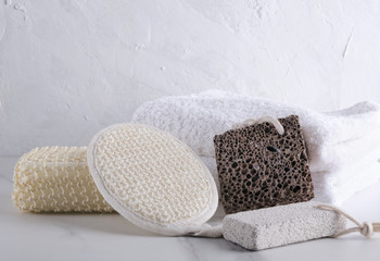 Bath sponges, natural pumice on the white marble table