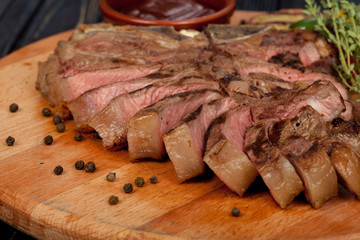 juicy, fried, tender steak with vegetables and sauces on a special stand