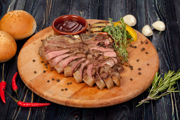 juicy, fried, tender steak with vegetables and sauces on a special stand