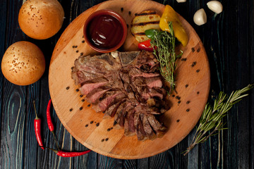 juicy, fried, tender steak with vegetables and sauces on a special stand