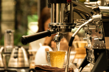 Barista using coffee machine for making unknown drinking in the cafe.