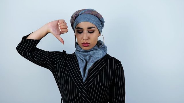 young beautiful arabic woman holding her finger down showing dislike on isolated white background