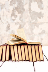 Stack of old ancient shabby books on a white wooden background.
