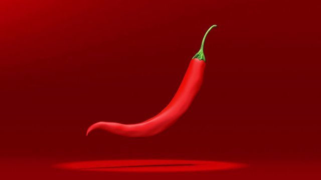 rotating red chili or chilli cayenne pepper isolated on red background.
