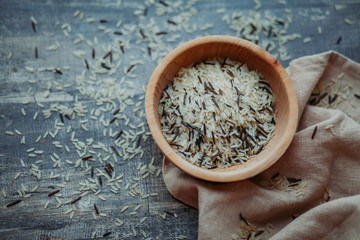 Close-up photo of black and white rice in a wooden plate  and linen serviette. Free space for text mockup 