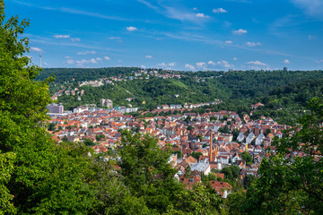 Germany, View from green forest above houses and buildings of stuttgart city in valley surrounded by trees, nature and hills