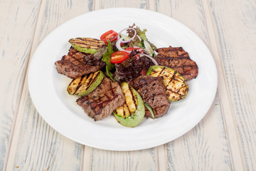 juicy, fried, tender steak with vegetables and sauces on a special stand