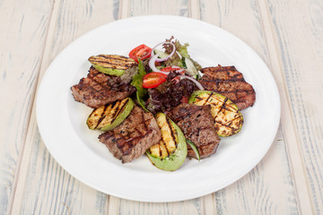 juicy, fried, tender steak with vegetables and sauces on a special stand