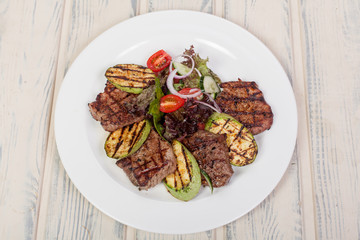 juicy, fried, tender steak with vegetables and sauces on a special stand