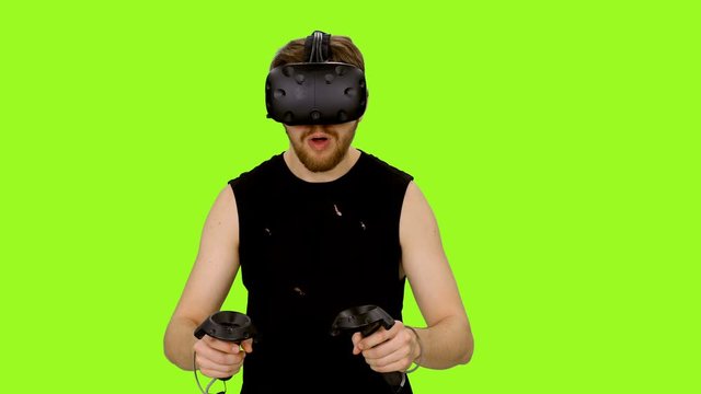 Man Wearing Virtual Reality Headset And Gaming On Green Screen Background, Chroma Key