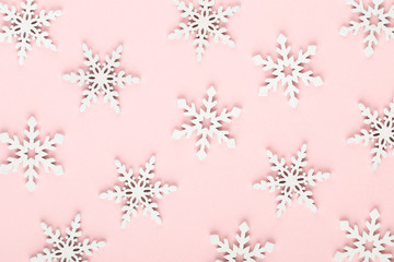 Christmas background. White snow decorations on a pink background.