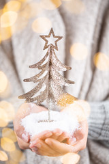 Christmas decor in women hand. Christmas greeting card. Woman's hands hold christmas or new year decorated gift.