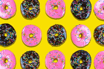 Sweet donuts with icing on yellow background