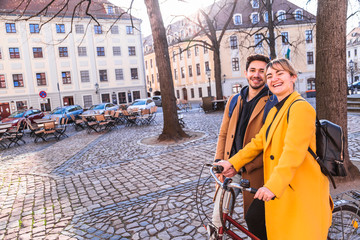 Young multicultural couple with bicycle in city