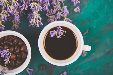 Coffee, coffee grain in cups and lavender flower on green background from above. Good Morning...