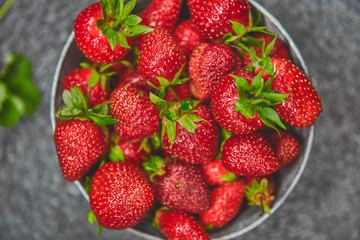 Ripe red strawberries on black table, Strawberries in white bowl. Fresh strawberries. grey strawberries. Diet food. Healthy, vegan. Top view. Flat lay.