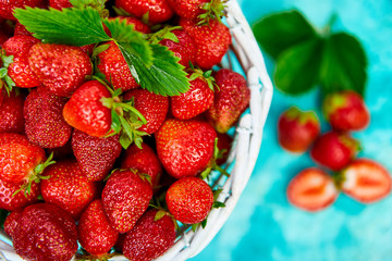 Ripe red strawberries on blue table, Strawberries in white basket. Fresh strawberries. Beautiful strawberries. Diet food. Healthy, vegan. Top view. Flat lay.