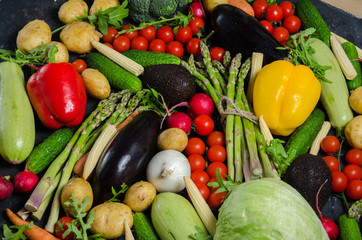 top view portrait of Assortment of fresh raw vegetables on black wooden background.
