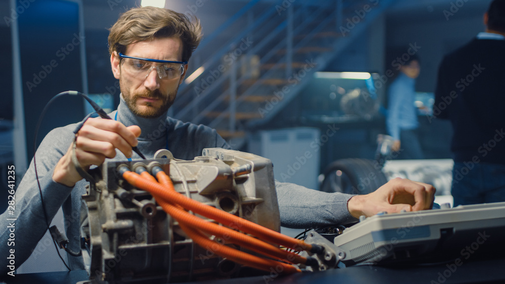 Fototapete professional automotive engineer in glasses with a computer and inspection tools is testing an used 