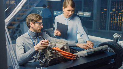 Male and Female Automotive Engineers with a Tablet Computer and Inspection Tools are Having a...