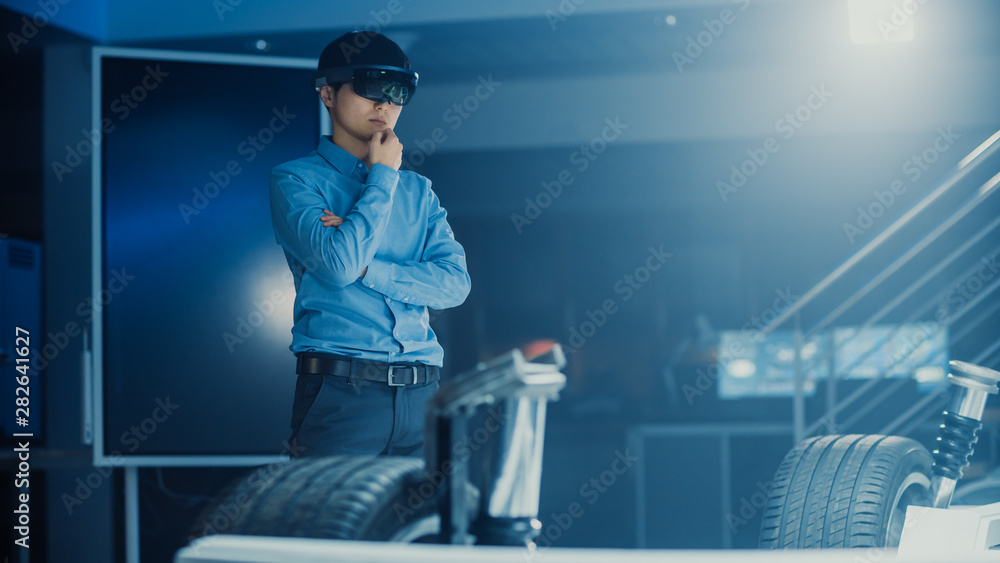 Poster automotive engineer working on electric car chassis platform, using augmented reality headset. in in