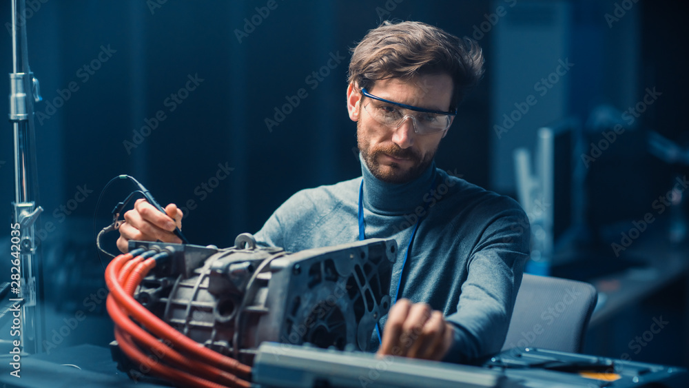 Leinwandbilder professional automotive engineer in glasses with a computer and inspection tools is testing an used 