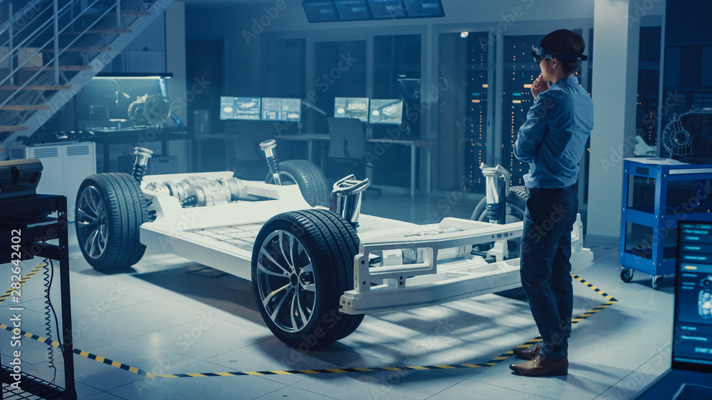 Poster automotive engineer working on electric car chassis platform, using augmented reality headset. in in