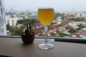 A glass of wine on the balcony on a tall building and clear sky