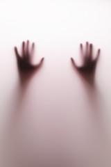 Shadow hands of the Man behind glass. Blurry hand abstraction. Halloween background.