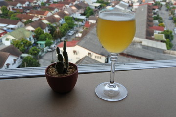 A glass of wine on the balcony on a tall building and clear sky