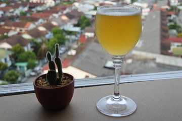 A glass of wine on the balcony on a tall building and clear sky