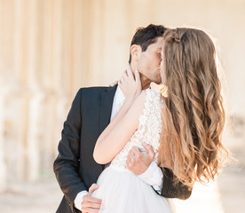 Closeup Portrait of wedding bride and groom with bouquet posing by the old cathedral. Bridal...