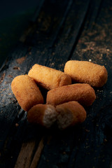 spanish croquettes on a rustic wooden table.