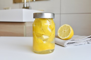 Lemon peel and vinegar cleaner in reusable jar, zero waste, eco-friendly home cleaning.