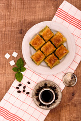 Turkish delights - baklava traditional sweets with turkish coffee, sugar the view from the top on wooden table and white fabric