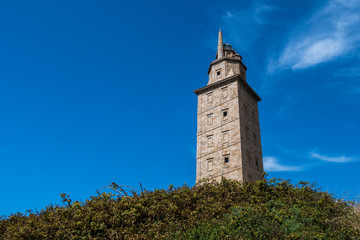 Fototapeta na wymiar View of the Tower of Hercules, in A Coruna, during a hot summer day. An ancient Roman lighthouse, the second-tallest lighthouse in Spain, National Monument and UNESCO World Heritage Site