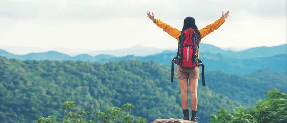 Poster Women hiker or traveler with backpack adventure feeling victorious facing on the mountain, outdoor for education nature on vacation. Travel and Lifestyle Concept © freebird7977