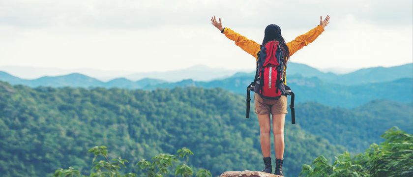 Women hiker or traveler with backpack adventure feeling victorious facing on the mountain, outdoor for education nature on vacation. Travel and Lifestyle Concept