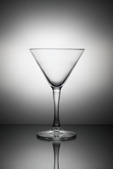 Empty martini glass on the table in backlight.