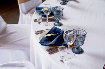 Classic table setting. Blue napkin and glasses. Banquet