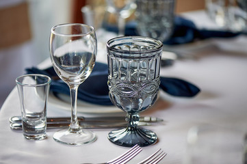 Classic table setting. Blue napkin and glasses. Banquet