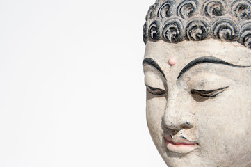 Fototapeta na wymiar Buddha Head Meditating On A White Background. Buddha is not a name, but a title. It is a Sanskrit word that means “a person who is awake.” What a buddha is awake to is the true nature of reality.
