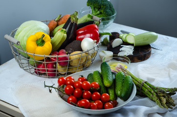 Fresh salad with cucumbers, cherry tomatoes, arugula, avocado, radish, red pepper on dark background. Cooking salad with vegetables.