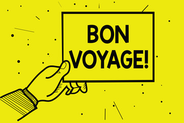Word writing text Bon Voyage. Business concept for used express good wishes to someone about set off on journey Man hand holding paper communicating information dotted yellow background