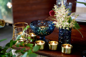 Decoration table newlyweds, blue dishes, bottles of flowers and candles. Wedding floristry.