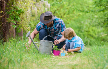 Growing plants. Take care of plants. Day of earth. Boy and father in nature. Gardening tools....