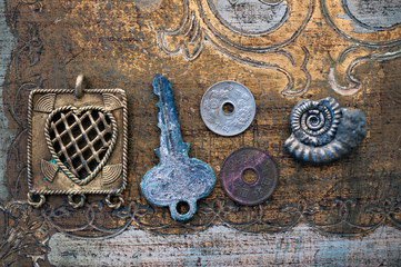 Still Life Photography of symbolic things: a heart, old key, two chinese coins, and a spiral nautilus fossil ammonite. Symbolic objects: relationship, romance, marriage, dreams, travel, or eternity. 